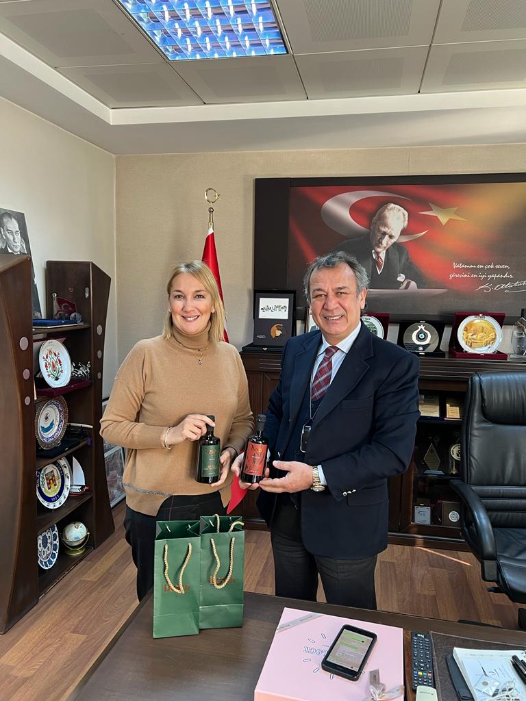 Fotoğrafta Beiza'nın kurucusu Beyza Telatar ile MİTSO Başkanı Reşir Özer yer alıyor. Ellerinde zeytinyağı dolu olan koyu renkli şişeleri tutuyorlar